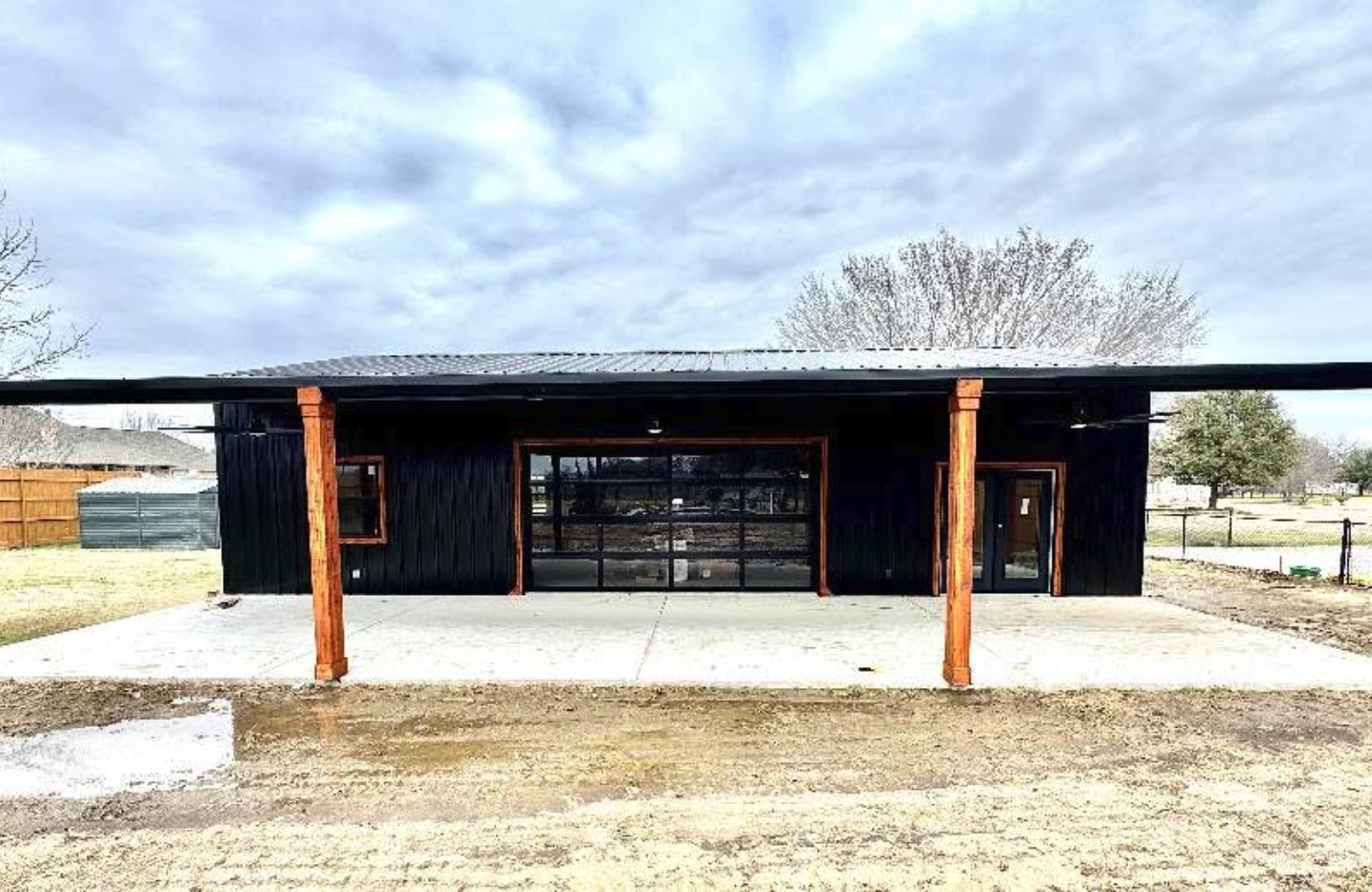 Black pavilion with cedar posts and glass roll up door