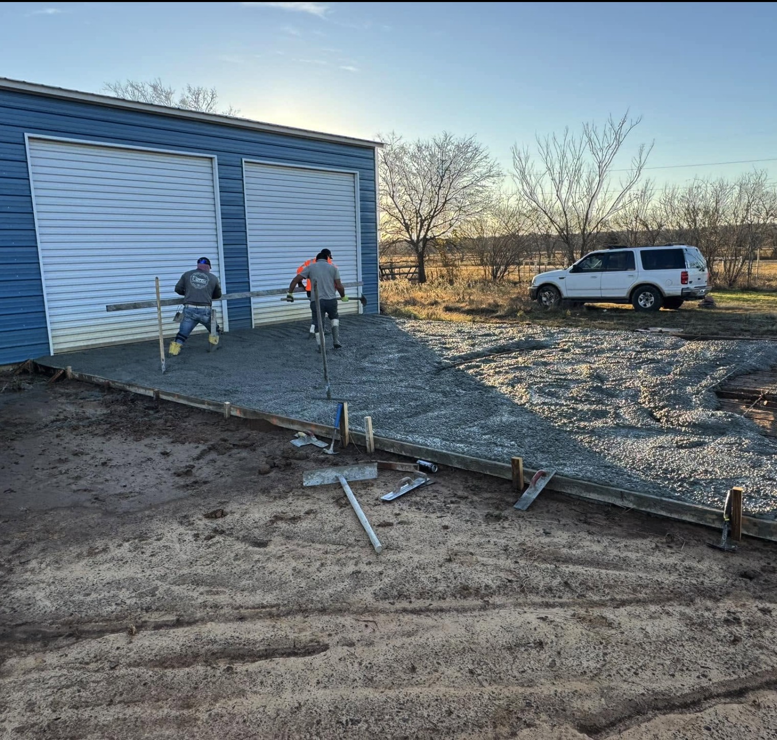 Next Level crew finishing a concrete pour at sunrise