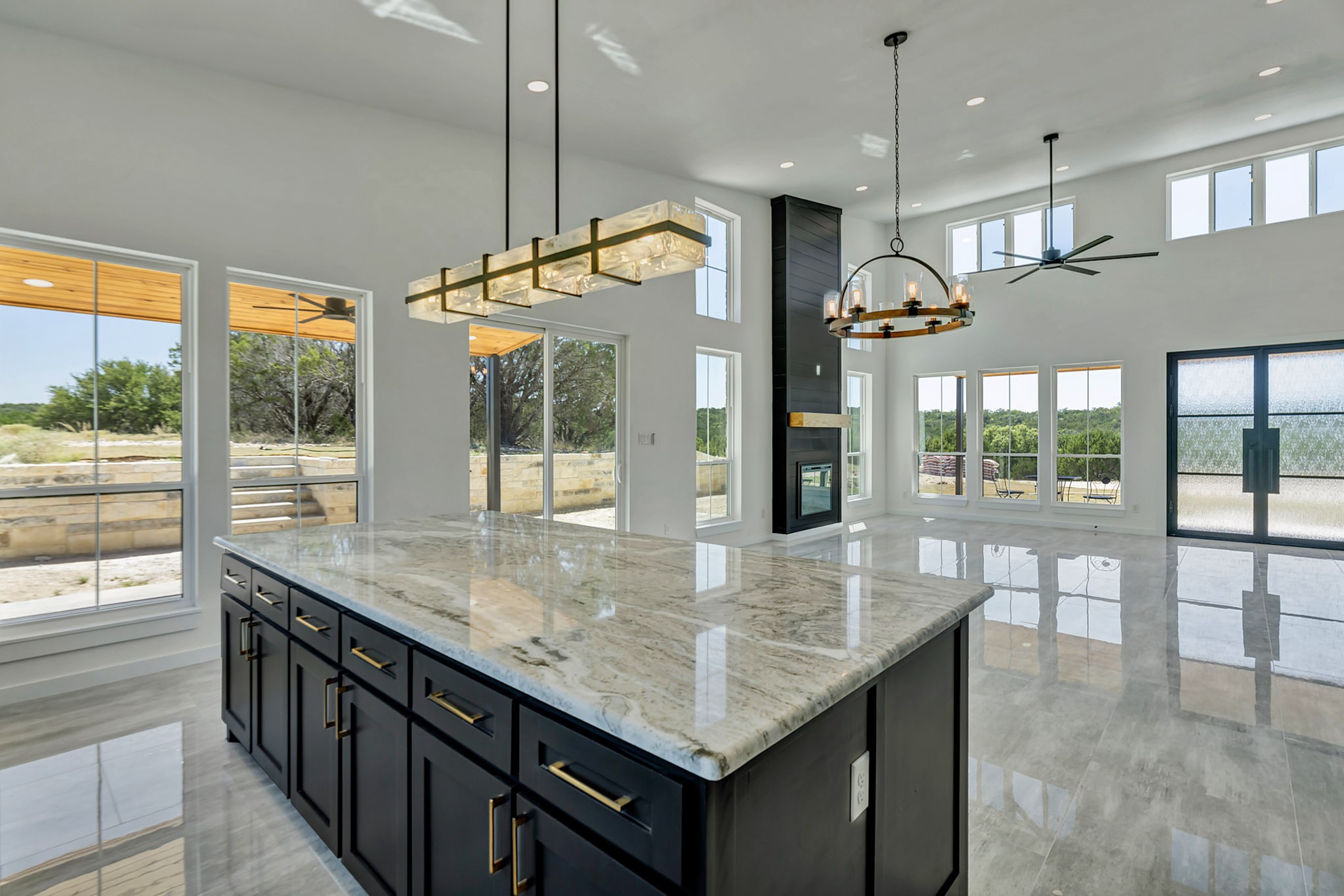 Open kitchen and great room with polished tile floors and a vaulted ceiling