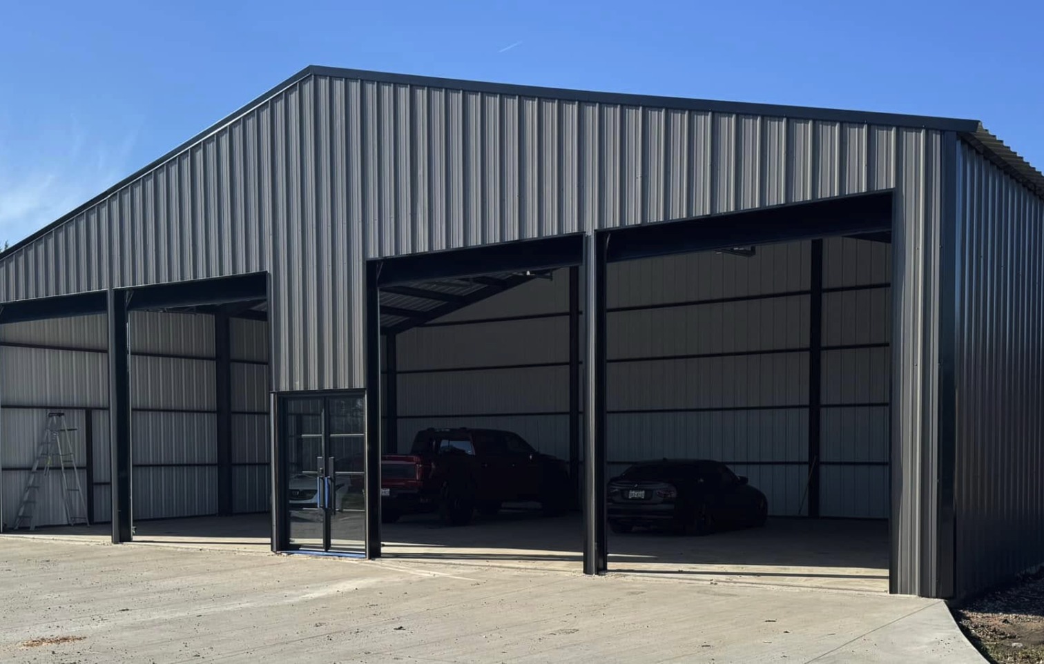 Grey shop with tall open bays deep enough for equipment