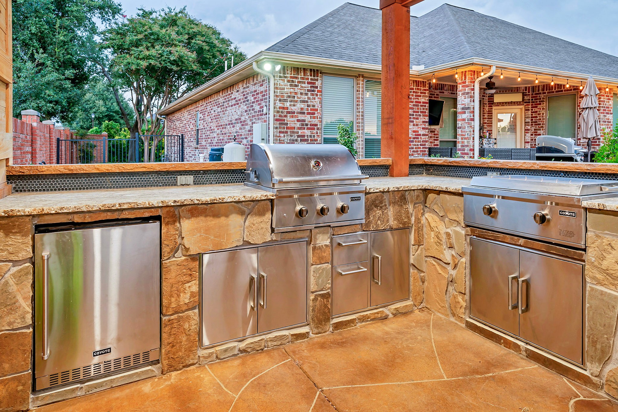 Stone outdoor kitchen with a built in grill and stainless drawers