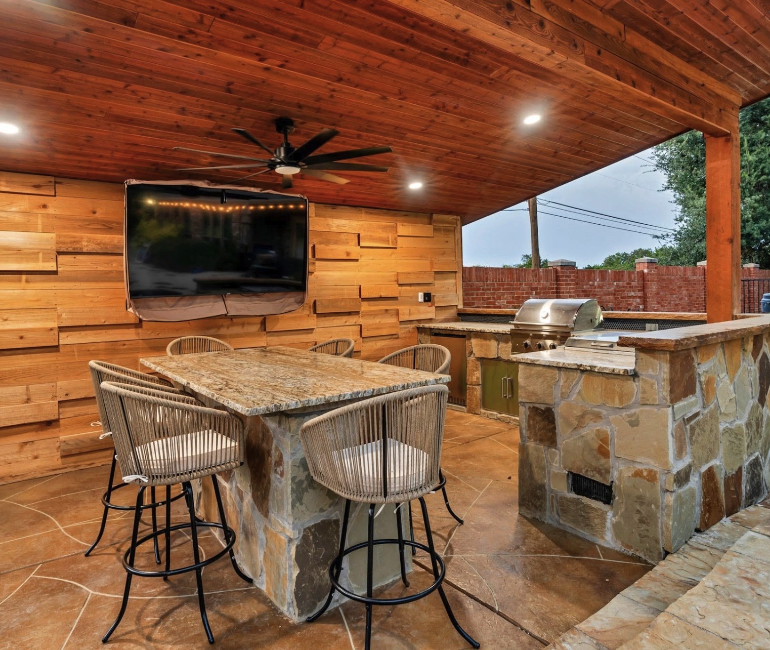 Outdoor kitchen with stone bar and built in grill
