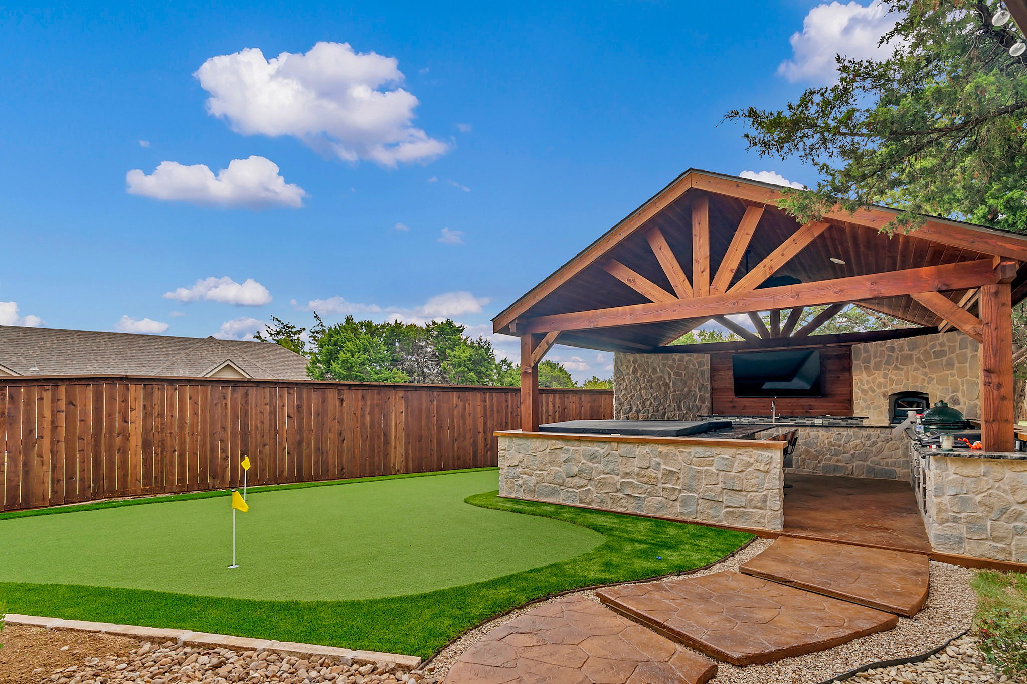 Timber pavilion with stone bar beside a putting green