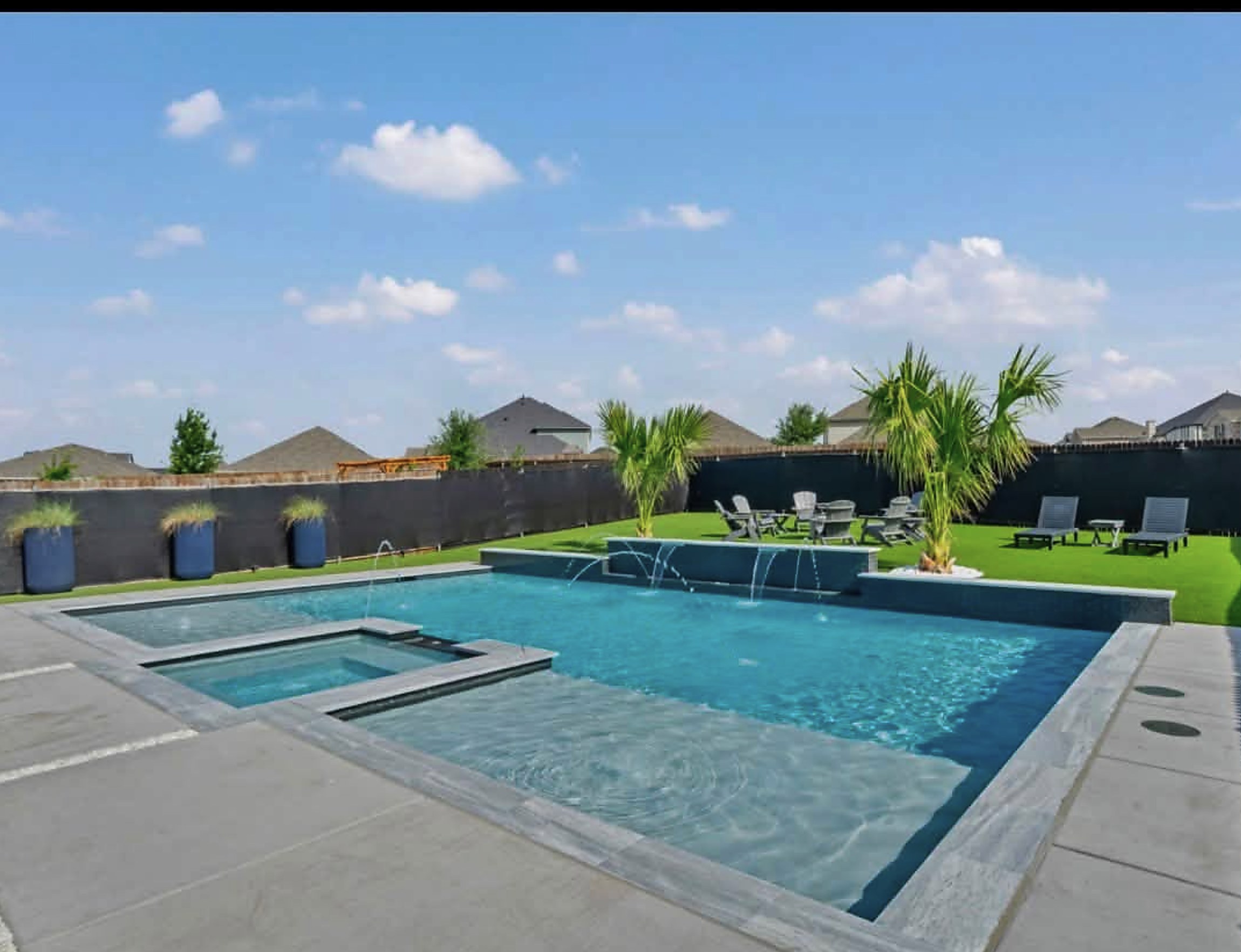 Pool with a tanning ledge, spa and paver decking