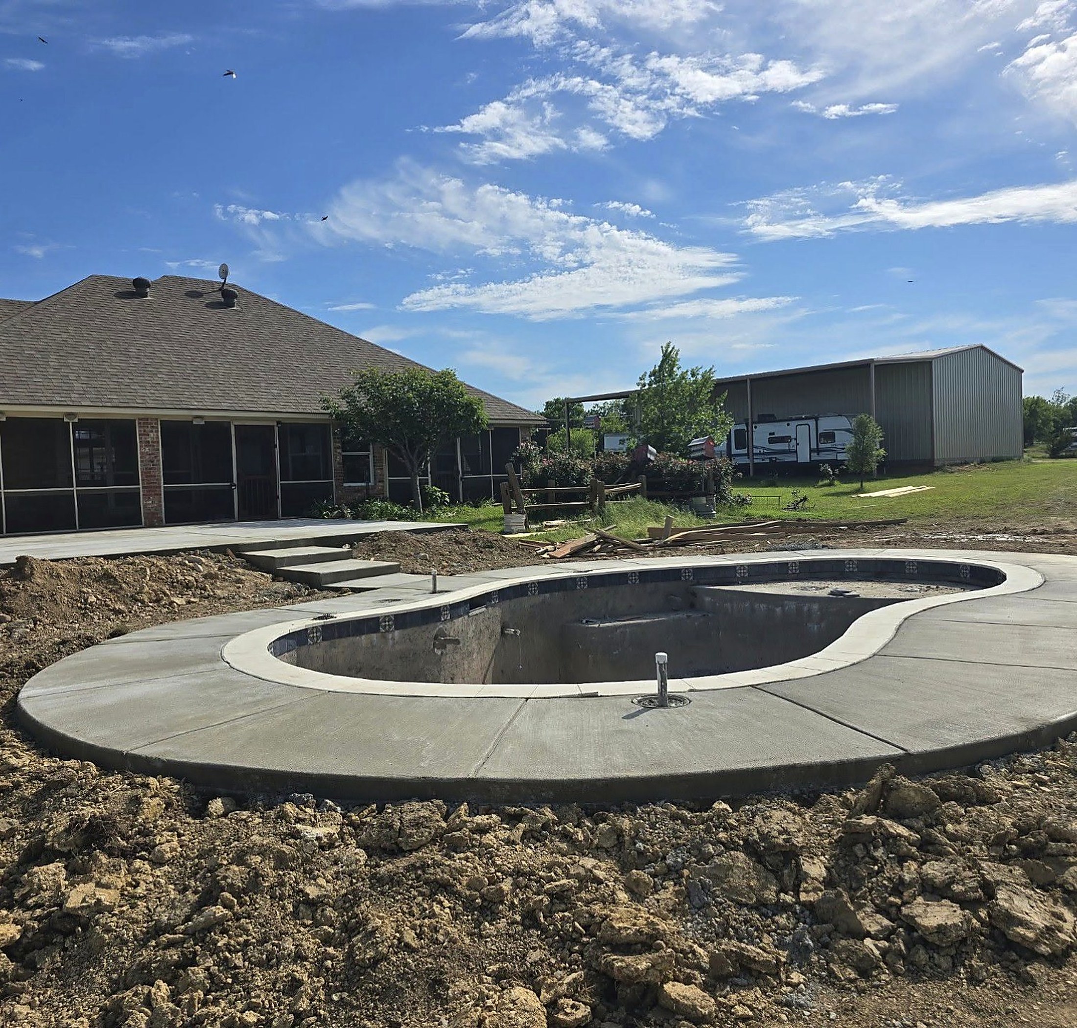 Gunite pool shell with coping set and the concrete deck poured