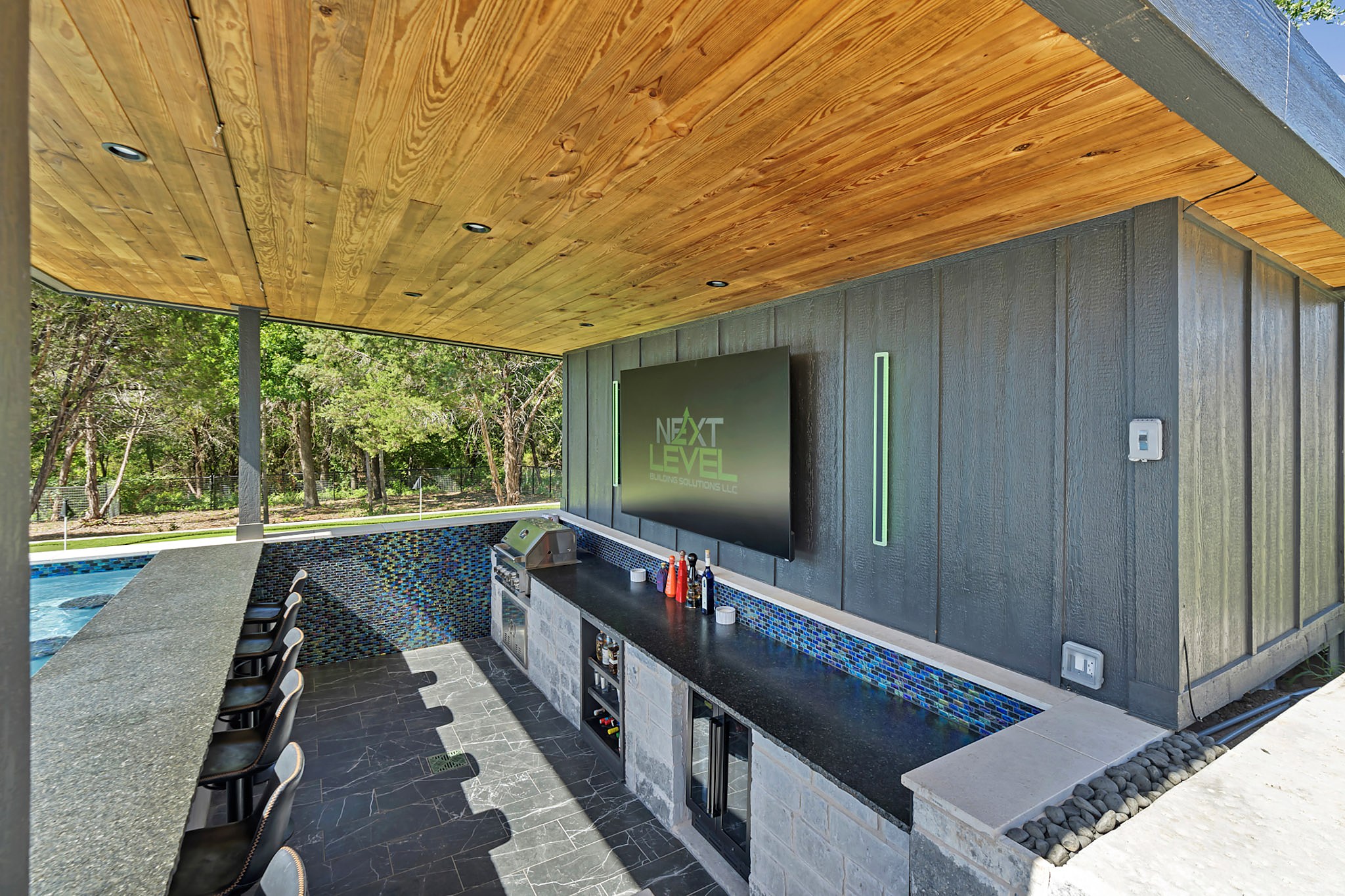 Swim up bar with in water seating and a mounted TV